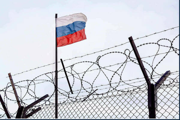 Russian flag behind barbed wire