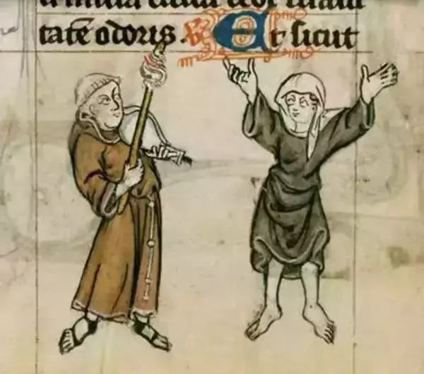 A small, hand-painted medieval manuscript scene on yellowed parchment. Two human figures stand facing each other beneath a band of black calligraphic text with a large, decorative blue-and-red letter. On the left, a person in a long brown robe and head covering holds a tall staff or pole angled upward, with one hand gesturing outward. On the right, a person in a dark robe and head covering stands barefoot with both arms lifted, as if speaking or celebrating. The drawing is outlined in dark ink with muted brown, green, and gray tones, and the background is plain, showing faint lines and age marks in the parchment.